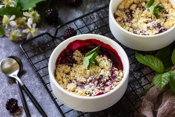 Homemade summer dessert. Blackberry crumble in baking dish on a stone countertop.