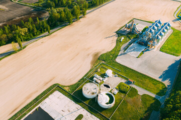 Biogas Bio-gas Plant From Pig Farm And Granary, Grain-drying Complex, Commercial Grain Or Seed Silos In Sunny Spring Rural Landscape. Corn Dryer Silos, Inland Grain Terminal, Elevators