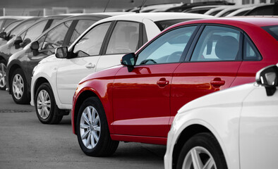 Fototapeta na wymiar Black and white image of a row of cars. Only the red car has color