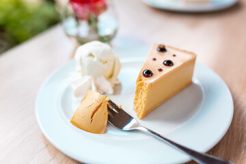 A piece of caramel cheesecake served with ice cream