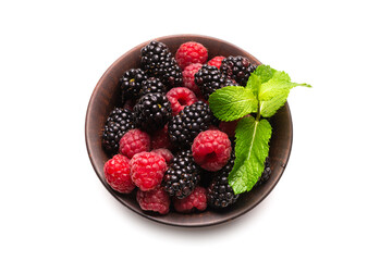 Raspberry, blackberry and mint leaf in ceramic brown bowl isolated on white