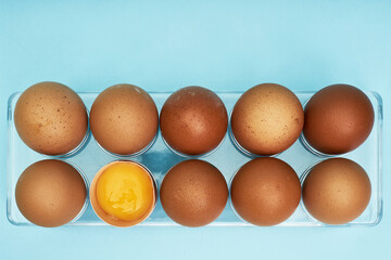 Chicken eggs in an egg holder. Full tray of eggs. Half an egg, egg yolk, shell. Food, protein in foods.