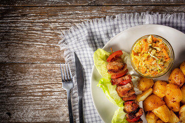Shish kebab served with roasted potatoes and salad.