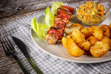 Shish kebab served with roasted potatoes and salad.