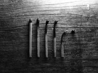 Different stages of match burning. Burnt matches isolated on wood background. Creative background