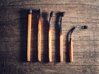Different stages of match burning. Burnt matches isolated on wood background. Creative background