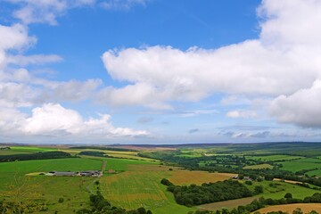Fototapeta na wymiar Blue cloudy sky, above farmland and moorland in Harwood Dale, North Yorkshire, England.
