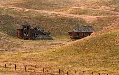 Fototapeta premium Historic homestead is the old pioneer mansion. It's been abandoned since 1921 and nestled into the gentle rolling hills of the landscape. 