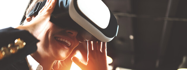 Happy office woman using virtual reality helmet and testing new vr technology. Wide screen,...