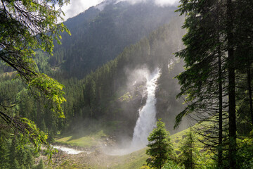 huge waterfall in the mountains between trees