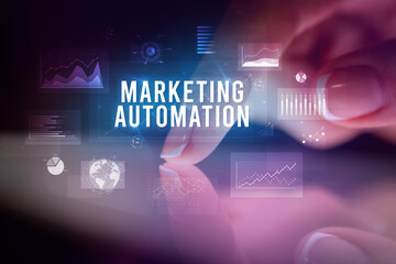 Finger touching tablet with charts and MARKETING AUTOMATION inscription, business concept