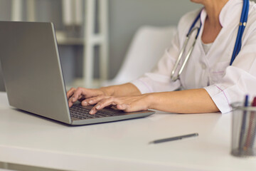 Concept doctor online. Doctor's hands are typing on a laptop keyboard a message web chat consultation medical clinic.