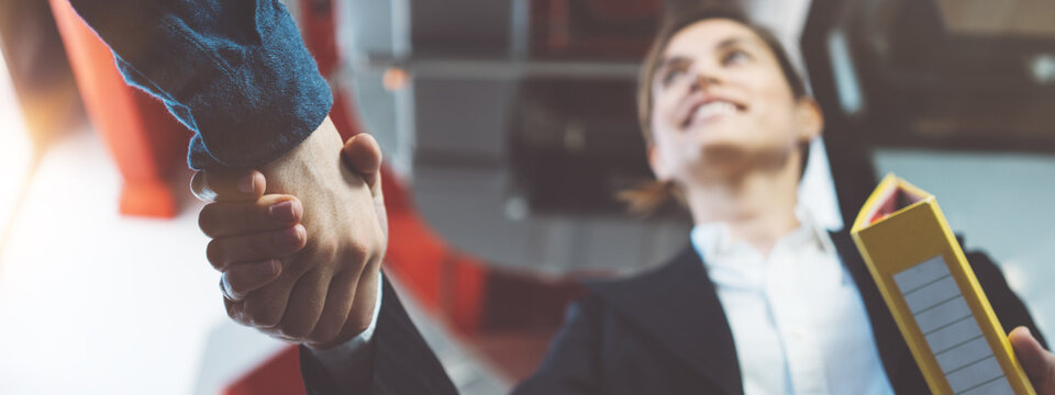 Two business people shaking hands after meeting. Finishing successful transaction and partnership. Wide screen, panoramic