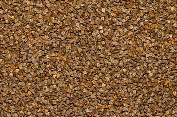 Common buckwheat seeds with husks, surface and background. Gluten-free pseudocereal with grain-like seeds, used as a cover crop. Fagopyrum esculentum. Food photo, top view, from above.