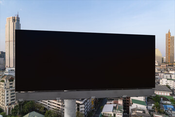 Blank black road billboard with Bangkok cityscape background at day time. Street advertising poster, mock up, 3D rendering. Front view. The concept of marketing communication to promote or sell idea.