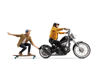 Fototapeta na wymiar Elderly man riding a chopper and pulling a guy on a skateboard