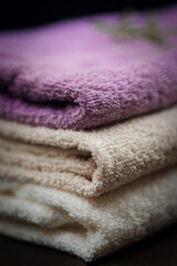Fototapeta na wymiar Towels over dark wooden background. Spa products