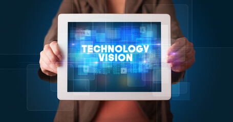 Young business person working on tablet and shows the inscription: TECHNOLOGY VISION
