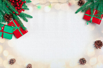 Fototapeta na wymiar Christmas composition. Christmas gift, pine cones, fir branches, christmas light, garland on white paper background. Top view, copy space