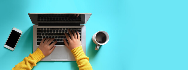 Woman hands is using a computer laptop at the colorful background.