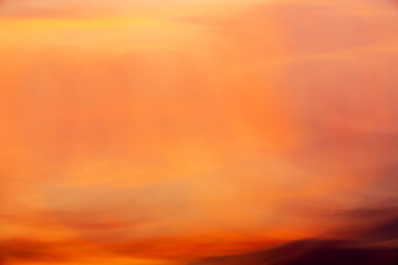 Pastel red-yellow sunset clouds shooted with long shutter speed and wave camera motion. Abstract background