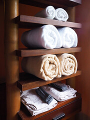 Towels on shelves of wooden furniture decor in bathroom