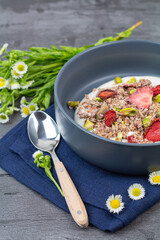 Bol bleu, granola de fraises et pistaches et fleurs des champs