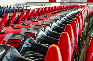 Empty shopping carts assembled in a row at a parking lot of a shopping center, selective focus