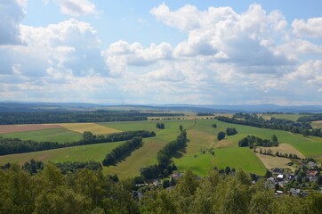 Fototapeta na wymiar Schöne Aussicht über Hügellandschaft im Sommer mit Wolkenhimmel