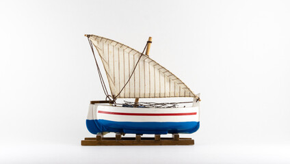 Toy sailing blue boat on a white background