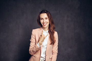 Adult woman show rock gesture on dark background