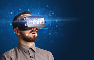 Businessman looking through Virtual Reality glasses with CUSTOMER EXPERIENCE inscription, social networking concept