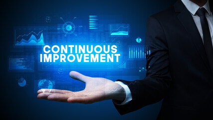 Hand of Businessman holding CONTINUOUS IMPROVEMENT inscription, business success concept