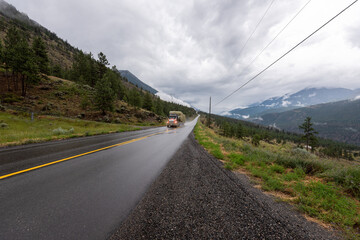 Truck driving on a long winding road in British Columbia Canada transporting bales of hay 
