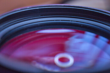 Closeup camera lens with reflection on red