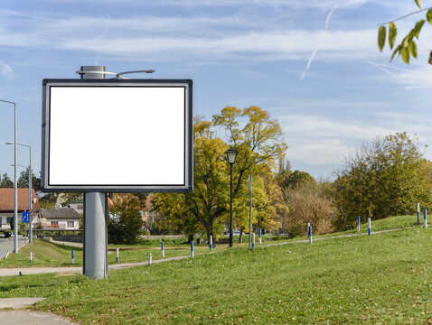 Big gray billboard on green hill city road street and green lawn with cloudy sky