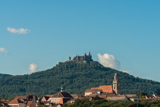 Aufnahme an einem sonnigen Tag von der Stadt Hechingen im Vordergrund und der Burg Hohenzollern im Hintergrund, Deutschland