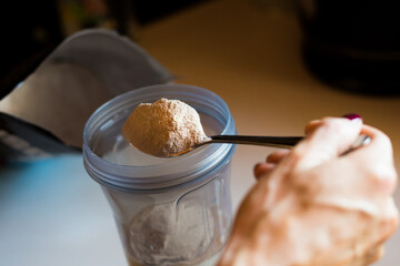 girl's hands with vitiligo making a protein shake after sport