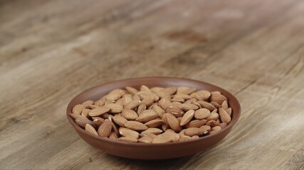 Bowl with almonds on wooden table