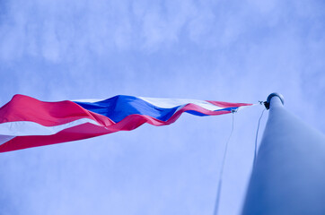 The Thai flag on a tall pole and blown by the wind