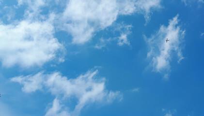Naklejka na ściany i meble the plane flies in the sky in beautiful clouds.