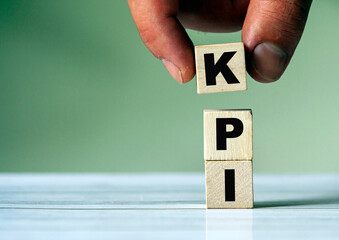 hand puts the cube block with the inscription KPI