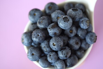 blueberries in a bowl macro on purle background