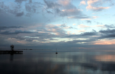 Pacific Northwest ocean shoreline landscape / seascape with dynamic clouds and pastel colors reflected on pristine water at sunrise