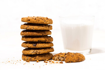 oatmeal cookies with chocolate chips on a white background and a glass of milk