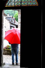 Man standing with a red umbrella