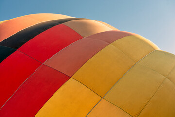Fototapeta premium Balloon flying high in the sky. Aerostat close-up. Aeronautic sport. Burning gas. Bright multi-colored hot air balloon. Romantic trip.