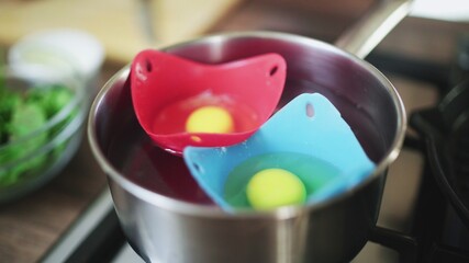 Breaking eggs in metal saucepan with water