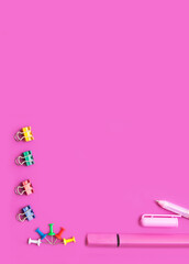 Set of office supplies on a pink background, top view