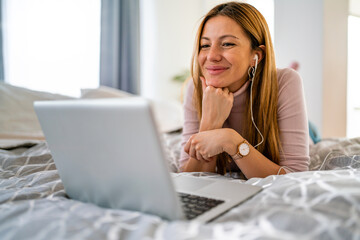 Happy young woman using laptop at home